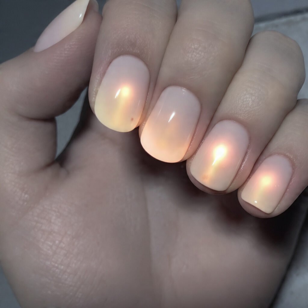 neutral nails with a soft aura glow