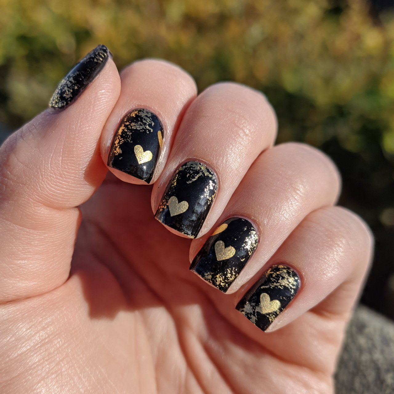 black base with gold hearts nature look nails