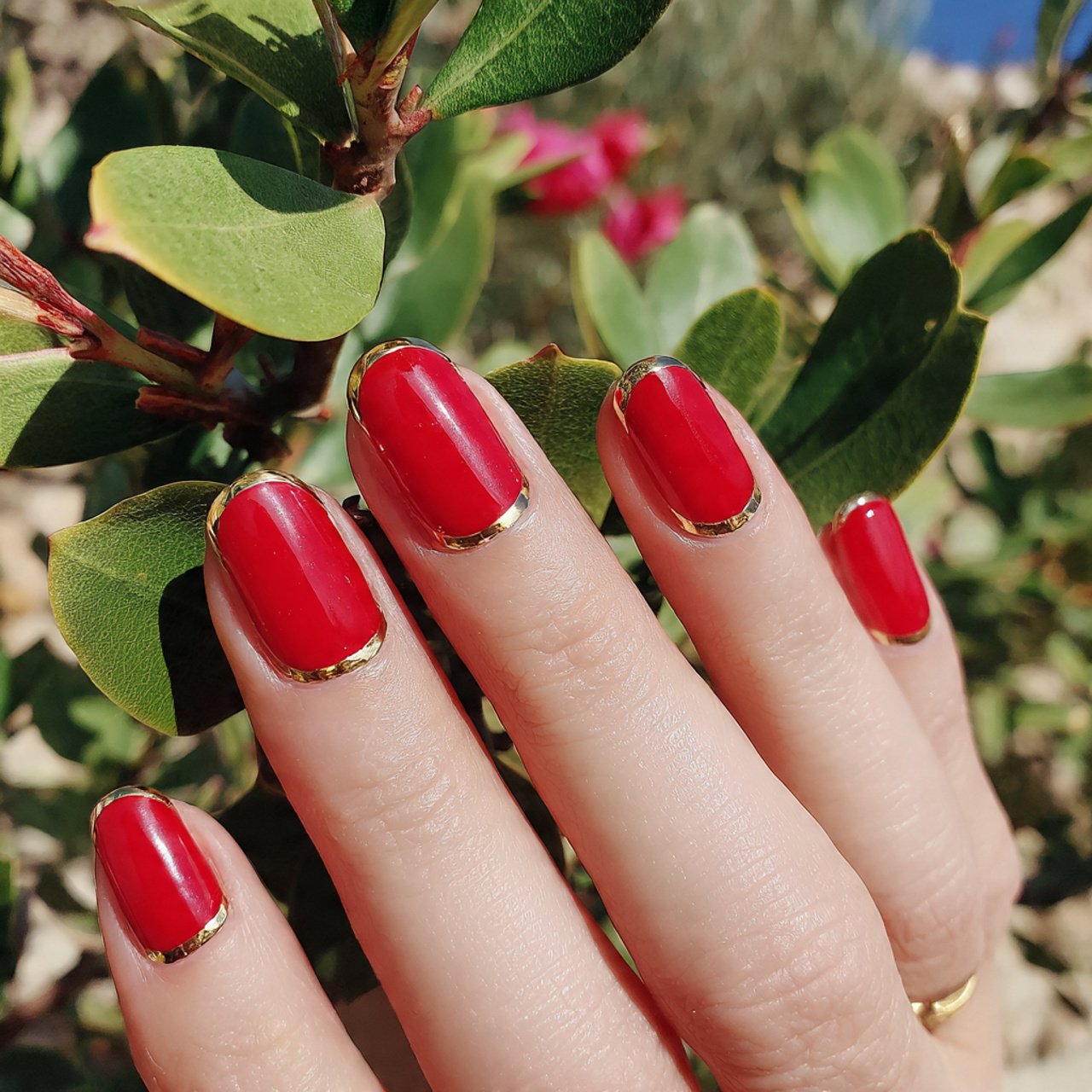 classic red manicure with gold accent tips nature