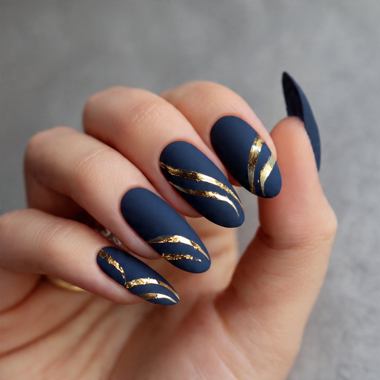 matte navy nails with glossy gold swoops nails